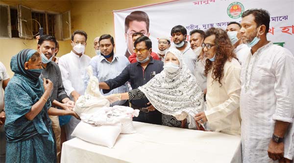 Councilor of 34 No Ward of DSCC Mohammad Mamun distributes relief materials among the distressed people from PM's Relief Fund in the city's Nazira Bazar area on Friday.