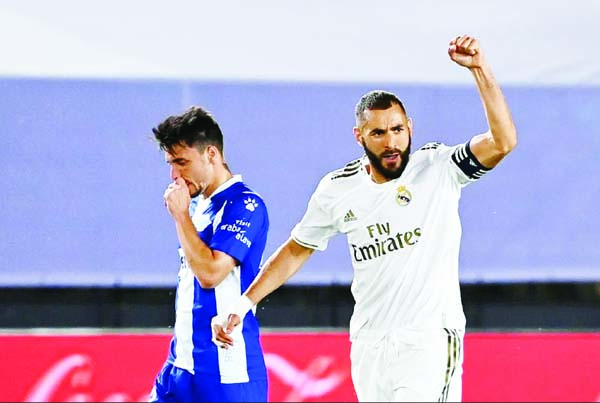 Real Madrid's forward Karim Benzema celebrates next to Alaves' Spanish defender Ximo Navarro (left) after scoring a goal during the Spanish League football match between Real Madrid and Alaves at the Alfredo Di Stefano stadium in Valdebebas near Madrid