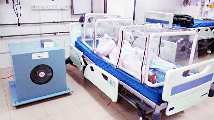 The first prototype of the Negative Pressure Isolation Canopy developed by Professor Rabbani's team, being demonstrated at BSMMU. The blue box beside the bed houses the UVC disinfection chamber and the HEPA Filter.