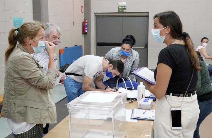 Workers organize papers at a polling station before the start of the voting during the Basque regional elections, amid the coronavirus outbreak, in Durango, Spain on Sunday.