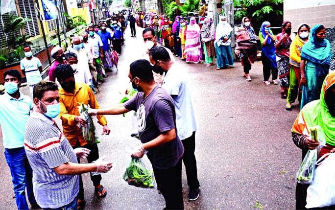 Vegetables being distributed among the dwellers of the city's Wari Red Zone area on Tuesday on behalf of DSCC Mayor Sheikh Fazle Noor Taposh and Councillor of 41 No. Ward of the corporation Sarwar Hasan Alo to tackle coronavirus pandemic.