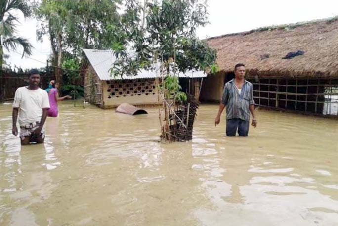 People wade through flood water as flood situation deteriorated in a village of western Nepal.