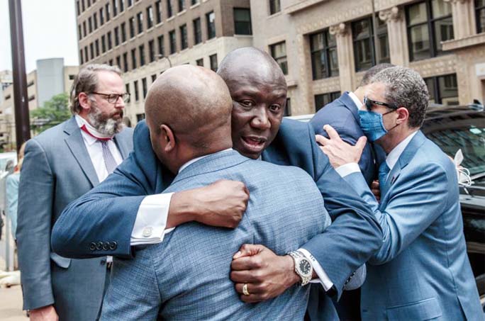 Attorney Ben Crump hugs his legal team as they leave after a press conference outside the federal courthouse in Minneapolis on Wednesday.