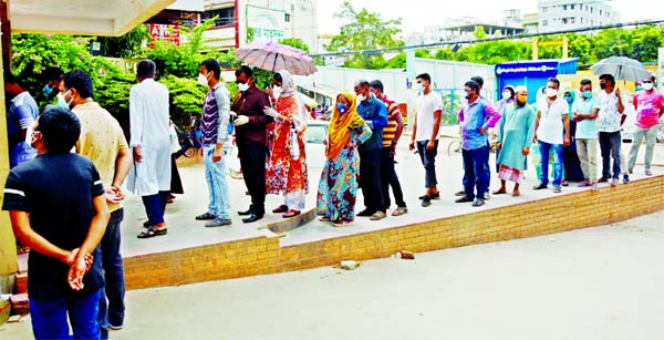People are seen waiting in a long queue in front of Mugda General Hospital for Corona test on Thursday.
