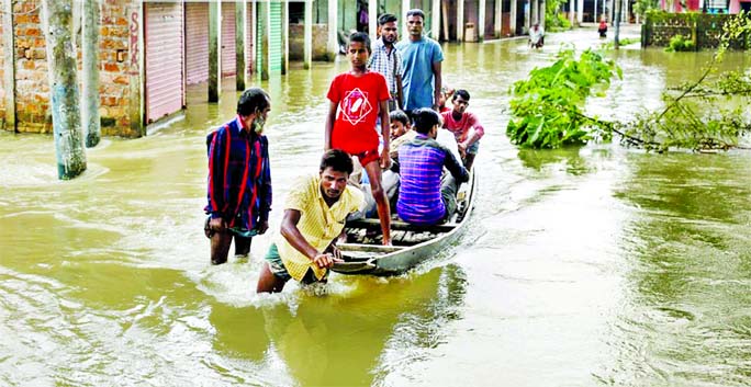 Although water in the Shurma River is receding, the Govindaganj Union of Chhatak upazila is still under water. People are going to one place to another by boat. The photo was taken on Friday.