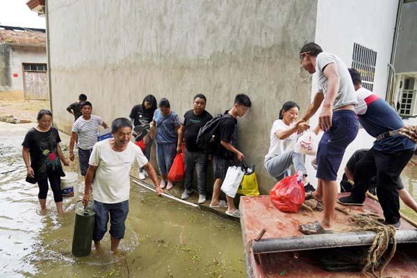 Residents stranded by floodwaters line up to get on a boat to evacuate the flood-hit village in Poyang county, Jiangxi province, China on Thursday.