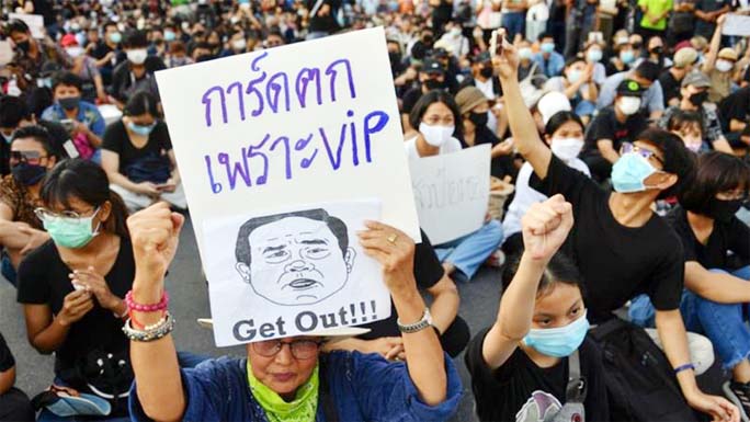 A protester holds a sign depicting Thai Prime Minister Prayuth Chan-ocha during a protest demanding the resignation of his government, while defying the coronavirus disease restrictions on large gatherings in the capital, Bangkok.