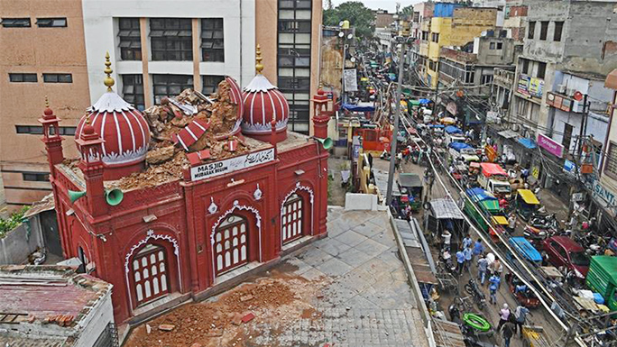 A partially damaged portion of historic Mubarak Begum mosque is seen next to a busy road after heavy rains in the old quarters of New Delhi.