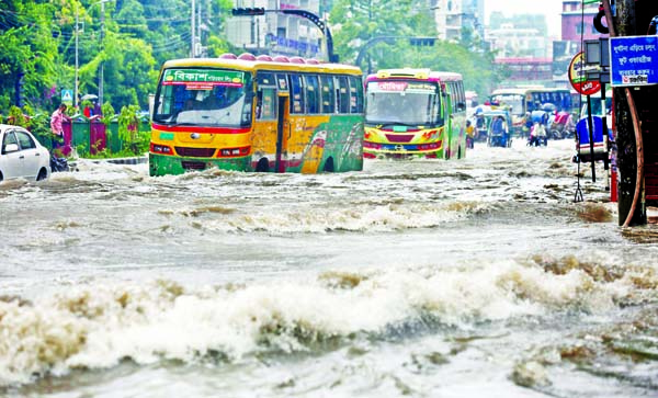 Vehicles wading through the waterlogged Dhanmodi 27 No Road after an early morningâ€™s heavy rain spell on Monday.