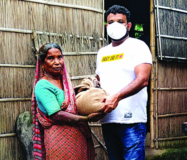 Shahadat Hossain Munna, Vice-Chairman of Shristy Human Rights Society distributes foodstuff among the flood-hit people at Daripur of Shibchar in Madaripur district on Tuesday.