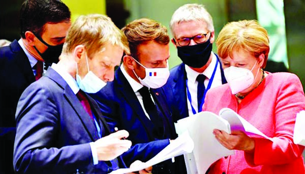 Spain's Prime Minister Pedro Sanchez (left), French President Emmanuel Macron (center) and German Chancellor Angela Merkel (right) looking at documents during the EU summit in Brussels on Monday. Photo: Agency