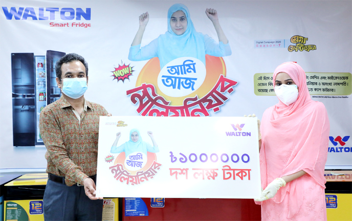 Md. Humayun Kabir, Executive Director of Walton Group, handing over a cheque of Tk 10 lakh to Suchona Rahman, who became a millionaire buying a refrigerator, at Walton Plaza in the capital's Mirpur-10 on Wednesday.