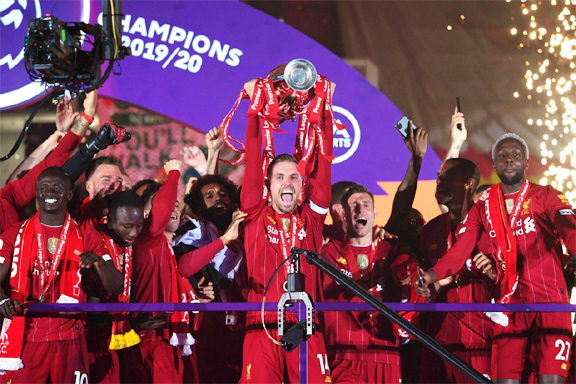 Liverpool's Jordan Henderson celebrates with teammates with the trophy on Wednesday after winning over Chelsea in the Premier League.