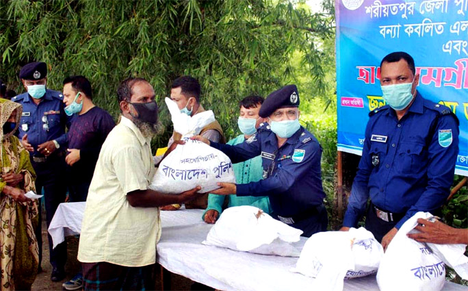Police Super of Shariatpur SM Ashrafuzzaman distributes relief materials among the flood affected people in Naria on Friday.