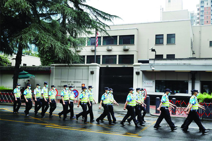 Police officers march past the U.S. Consulate General in Chengdu, Sichuan province, China on Saturday.