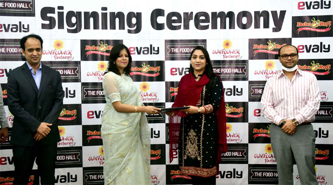 Yeasha Sobhan, Director of Bashundhara Group and Shamima Nasrin, Chairman of online market place Evaly, exchanging documents after signing an agreement to make ease home delivery of products through internet and mobile app of Bashundhara food chain at a s