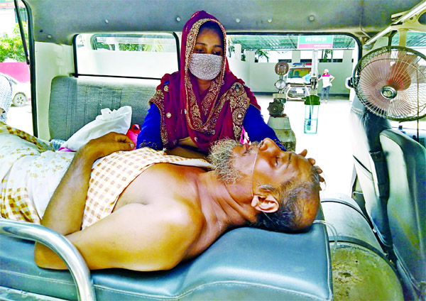 Relatives taking back a patient from Dhaka Medical College Hospital by an ambulance after he was denied admission there. The photo was taken from the Hospital's emergency department.