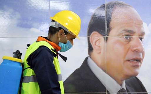 A member of a medical team is seen beside a banner for Egyptian President Abdel Fattah el-Sisi, as he sprays disinfectant as a precautionary move amid concerns over the coronavirus disease outbreak in Cairo. Internet