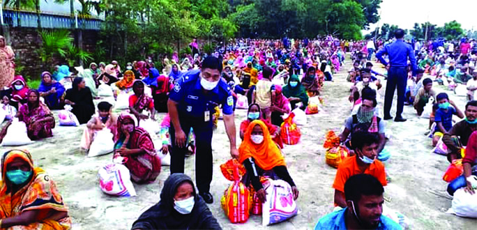 Asp Rakibul Hasan Russele on behalf of ex-ICP distributes relief among the flood victims at Dewanganj upazila of Jamalpur district on Tuesday.