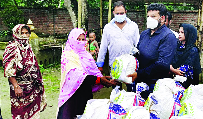 Shahadat Hossain Munna, Vice-Chairman of Srishti Human Rights Society distributes reliefs among the flood affected people at Sanyasir Char Union of Shibchar upazila, Madaripur on Wednesday.