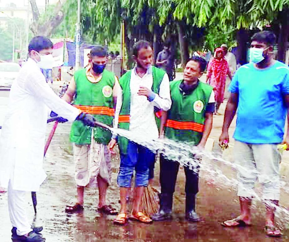 Commissioner of 26 No Ward of DSCC Hasibur Rahman Manik seen to clean road sprinkling water after a day of Eid-ul-Azha. The snap was taken from Dhakeshwari Mandir area.