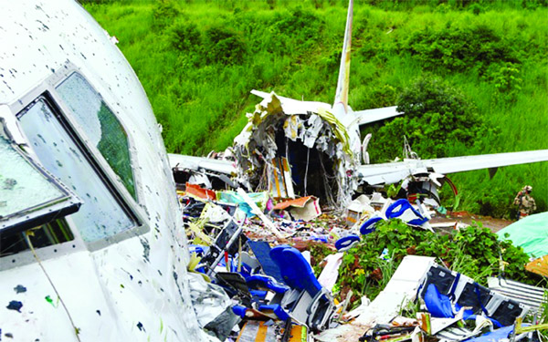 A security official inspects the site where a passenger plane crashed when it overshot the runway at the Calicut International Airport in Karipur, in the southern state of Kerala on Saturday
