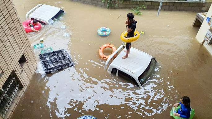 A resident waiting to be rescued from a market flooded by heavy rain in the southeastern county of Hadong in South Korea on Sunday.