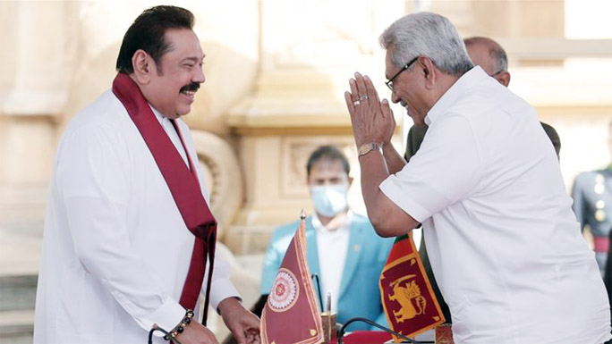 Rajapaksa brothers gesture during the swearing in ceremony at Kelaniya Buddhist temple in Colombo.