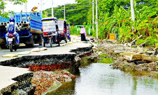 River erosion takes a dangerous turn in many areas with the recession of floodwater. The photo, taken from Sreenagar in Munshiganj on Thursday, shows a badly damaged road with enormous cracks making difficult and risky for smooth movement of vehicles.