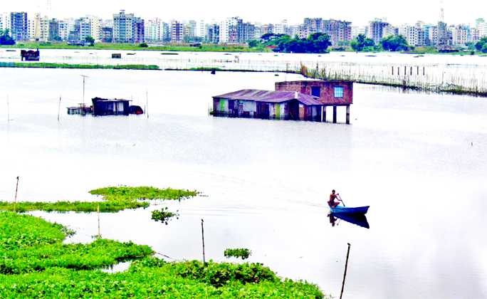 Low-lying areas in Dhaka city being inundated following rush of floodwater due to swell in water level of the surrounding rivers. This photo, taken from Badda's Satarkul area, shows a vast area along with houses gone under water.