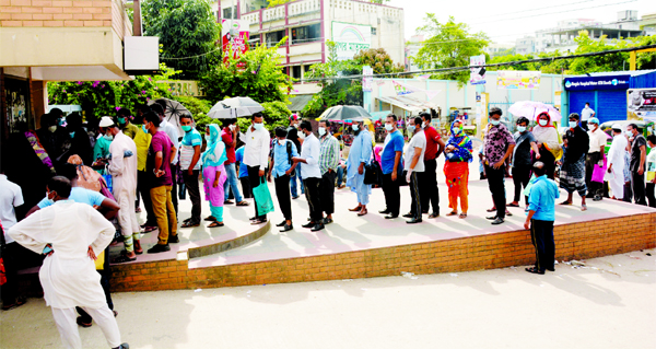 People stand in a long queue in front of the main entrance of Mugda General Hospital to get tested for coronavirus on Friday.