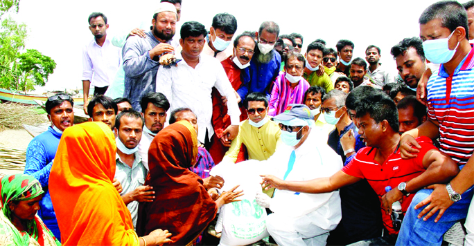 BNP Chairperson's Adviser Helaluzzaman Talukder Lalu distributes relief materials among the poor and the flood affected people. MP Golam Md. Siraj took the initiative on behalf of the party at Dhunotâ€™s Boraitoly Ghat in Bogura district on Friday.