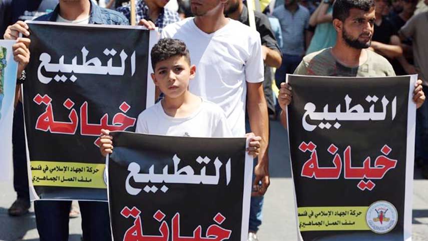 Palestinians hold banners reading 'normalisation is a treason' during a protest against the UAE deal with Israel to normalise relations.