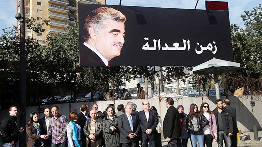 Supporters of slain former Prime Minister Rafik Hariri gather under his portrait and Arabic that reads 'time for justice'.