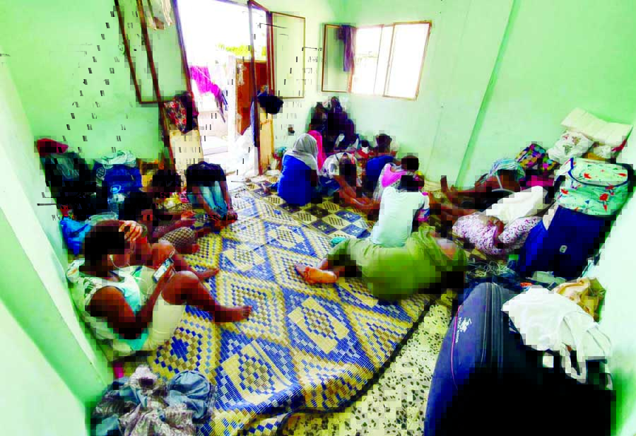 Migrant workers sit in a room on 8 August after being expelled by their employers in Beirut.