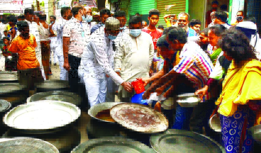 Councillor of 32 No. Ward of DSCC Hazi MA Mannan along with AL leaders distributes food among the destitute in the city's Bangshal area on Wednesday marking National Mourning Day.