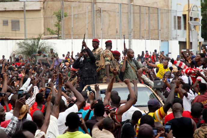 A crowd of people cheer Malian army soldiers at the Independence Square after a mutiny, in Bamako, Mali on Tuesday.