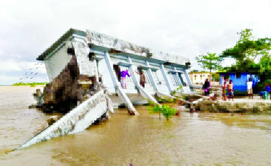 The two-storey building of Kazirsura Government Primary School in Bandarkhola union under Shibchar upazila of Madaripur is being gobbled up by the swelling Padma River on Tuesday.