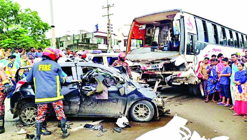 Firefighters and local people gather around the wreckage of a car that crashed into a bus on Dhaka-Mymensingh highway in Bhaluka upazila of Mymensingh on Saturday killing all six passengers of the private car.