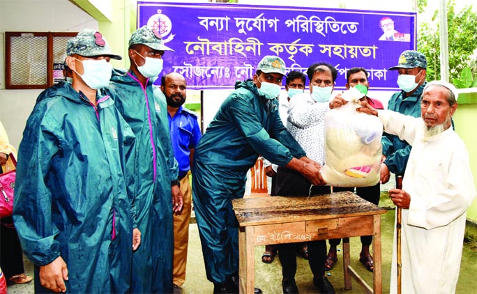 Members of Bangladesh Navy distribute dry food and relief materials among the flood affected people in Baishakanda and Rowain Unions of Demra PS in Dhaka on Sunday.