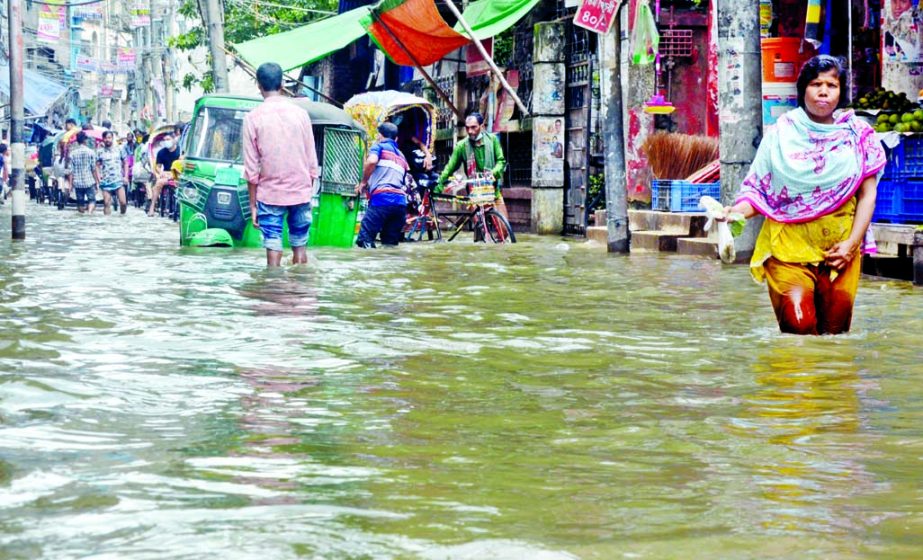 WOES BEGGER DESCRIPTION: Waterlogging has become a common scenario in different parts of the city due to haphazard and unplanned digging of roads by the utility service providers. This photo, taken from Aga Sadeq Road on Sunday, shows vehicles and dweller