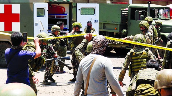 Military personnel move away some of the victims in the southern Philippine town of Jolo on Monday.