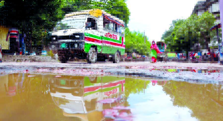 Vehicles in trouble as large-sized cracks and numerous potholes make difficulties for them to ply on the road in the capital's Tejgaon Industrial Area, but the authorities concerned remain uncared for. This photo was taken on Tuesday.