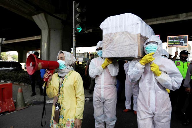 Government workers wearing protective suits carry a mock-up of a coffin of a coronavirus victim on a main road to warn people about the dangers of the disease as the outbreak continues in Jakarta, Indonesia, on Friday.