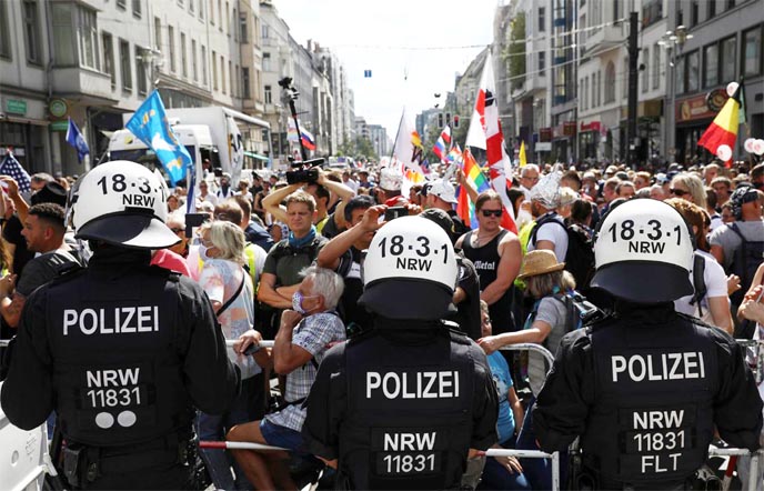 Police officers stand in front of demonstrators as they attend a rally against the government's restrictions following the coronavirus outbreak, in Berlin, Germany on Saturday.