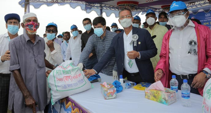 Dr. Md Habibe Millat, MP of Shirajgonj-2 along with Abdus Salam Azad, Managing Director of Janata Bank Limited, distributing food items among the flood affected people at Hard Point in Shirajgonj Sadar on Saturday organized by the bank. Md. Ismail Hossain