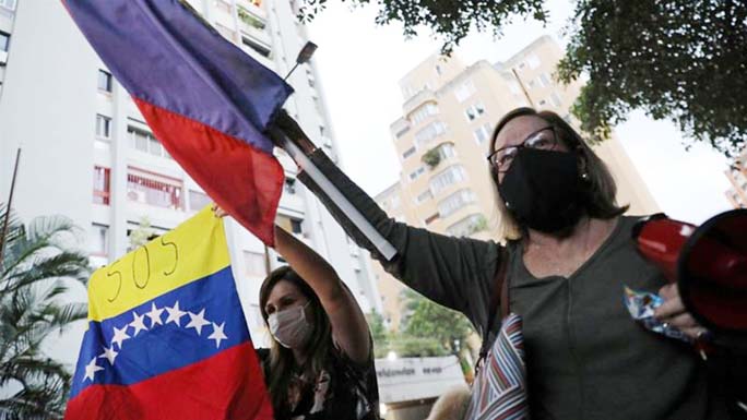 Supporters of Venezuelan lawmaker Juan Requesens shout slogans in front of his house after he was put on house arrest in Caracas.