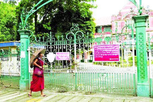 A Buddhist monk walks past a closed school amid the outbreak of the coronavirus, in Yangon, Myanmar.