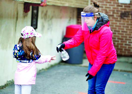 A student has her hands sanitized in the schoolyard, as schools outside the greater Montreal region begin to reopen their doors amid the coronavirus outbreak, in Saint-Jean-sur-Richelieu, Quebec, Canada.