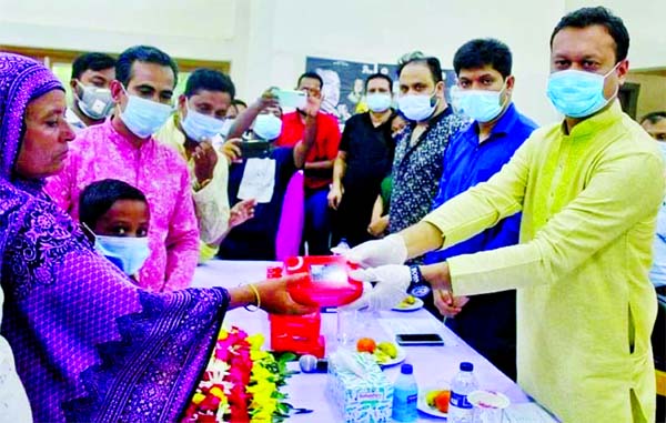 Fahim Golandaj Babel, MP, distributes mobile sets among the mothers of indigent students at Gaforgaon in Mymensingh on Thursday.